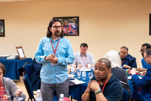 Shenandoah University Professor Bryan Pearce-Gonzales, Ph.D. standing, wearing a blue shirt.